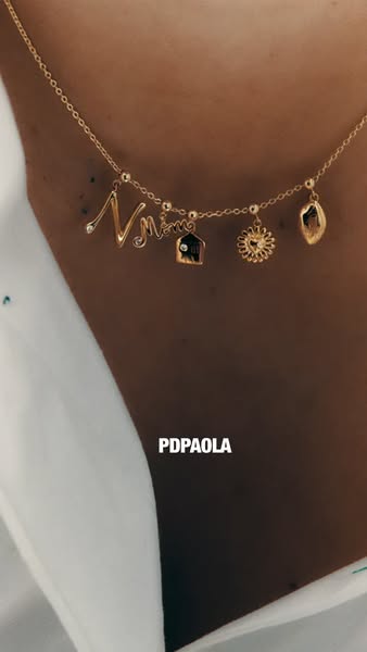 A close-up shot showcases a gold necklace with letter and charm pendants. The brand name, PDPAOLA, is displayed in white