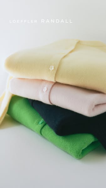 This ad showcases a stack of Loeffler Randall cardigans in varying colors.