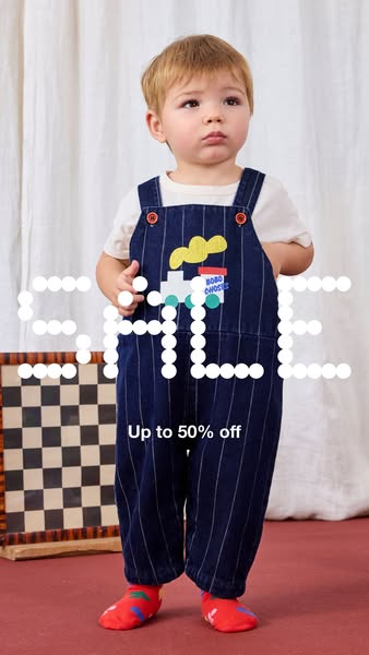 This ad showcases a young child wearing a pair of Bobo Choses overalls. The ad highlights a sale of up to 50% off.