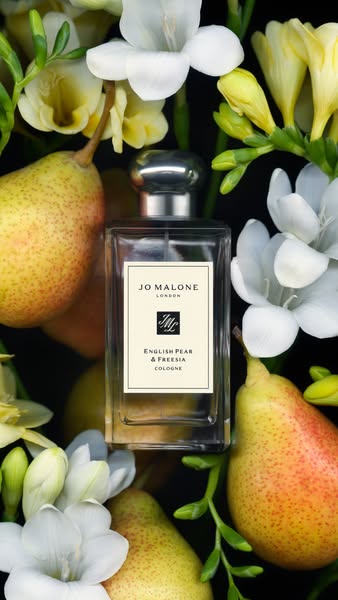 This ad features a perfume bottle surrounded by pears and white flowers.