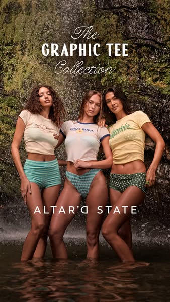 This image ad features three women wearing graphic tees and matching bottoms from the Altar'd State Graphic Tee Coll