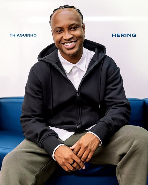 This ad features a headshot of Thiaguinho, a celebrity, wearing a black Hering hoodie and smiling at the camera. The ad 