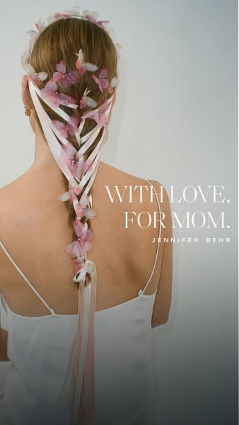 This image ad for Jennifer Behr features a woman from behind, showcasing a long braid adorned with white ribbons and del