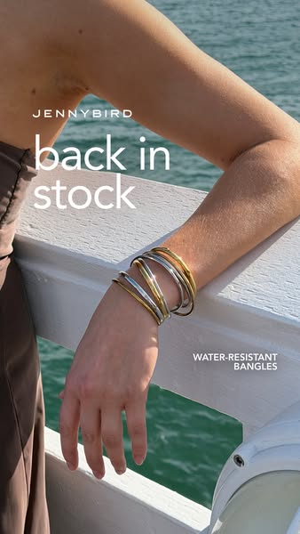 An image ad showcasing Jenny Bird bangles, emphasizing they are back in stock and water resistant.