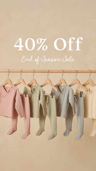 This image ad promotes a sale on baby clothing. The ad features a row of baby outfits hanging on a wooden rod against a 