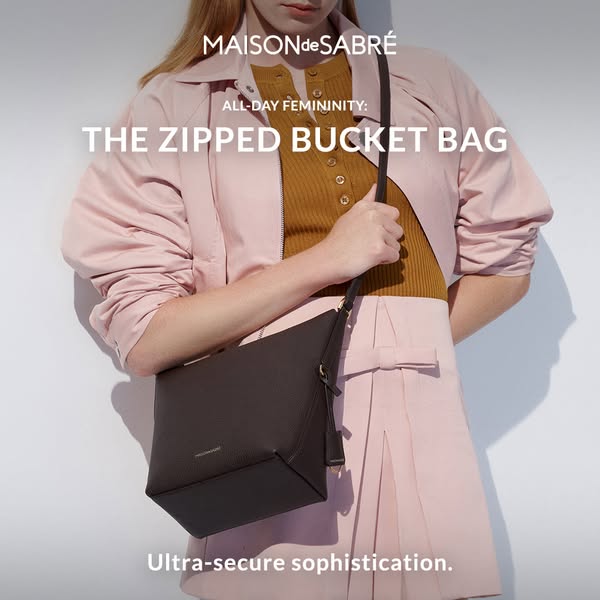 This is an image ad for Maison de Sabre featuring their zipped bucket bag. A model is holding the bag, and the ad highli
