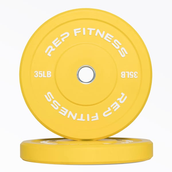 This ad features a close-up shot of two yellow REP FITNESS weight plates stacked on top of each other. The ad focuses on
