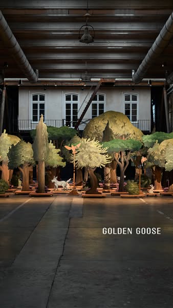 This image ad features a Golden Goose showcase of a staged forest with trees and animal figurines. The ad emphasizes the