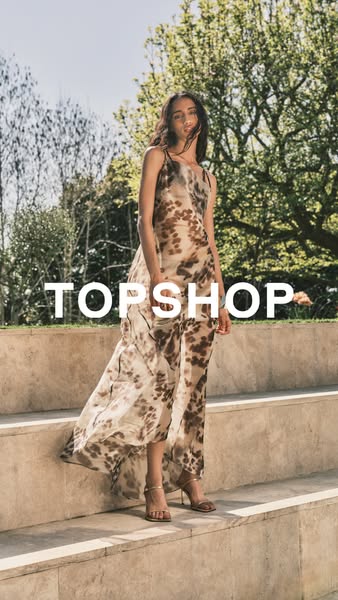 This image ad showcases a person standing on stone steps with trees in the background while wearing a flowy maxi dress f