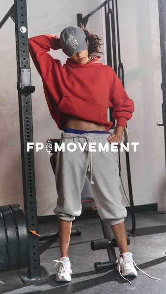 An image ad features a woman in athletic apparel from FP Movement, leaning against a weight rack in what appears to be a