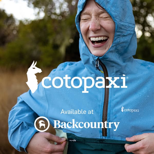 This ad features a woman wearing a Cotopaxi windbreaker in the rain. She is laughing and appears to be enjoying the weat