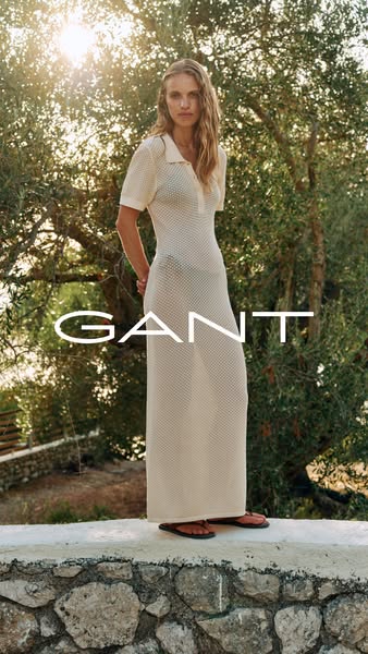 This ad features a woman wearing a mesh maxi dress from GANT. The shot is outdoors, set against a lush tree background a