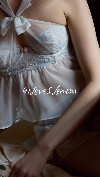 This ad features a woman wearing a light blue lingerie set from For Love & Lemons. The ad focuses on the delicate de