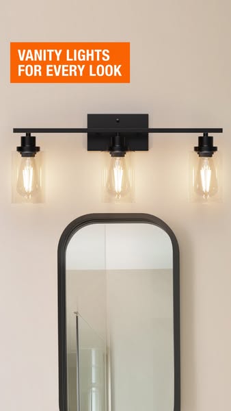 The ad promotes vanity lighting for bathrooms. The ad features a triple vanity light in black above a black framed mirro