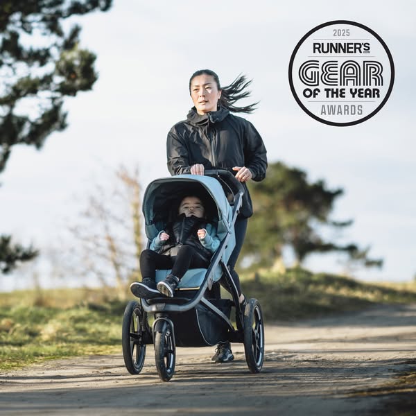 An image ad for a stroller, showcasing a woman jogging on an outdoor path while pushing her child in the stroller. The a