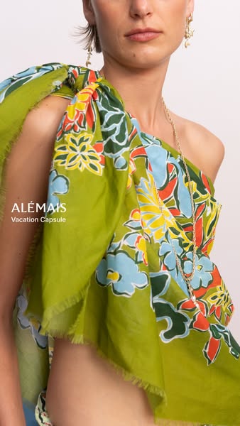 This image ad showcases a woman draped in a floral scarf, promoting the brand's vacation capsule.