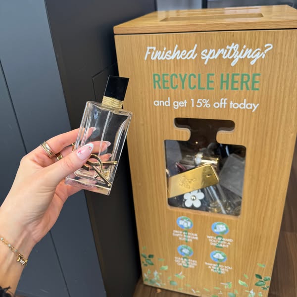An image ad that promotes the recycling of perfume bottles in exchange for a 15% discount. It features a person holding 