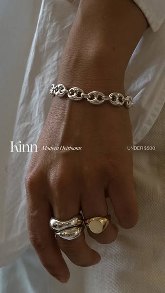 This image ad showcases Kinn jewelry, specifically a bracelet and rings, on a person's hand. The ad emphasizes the b