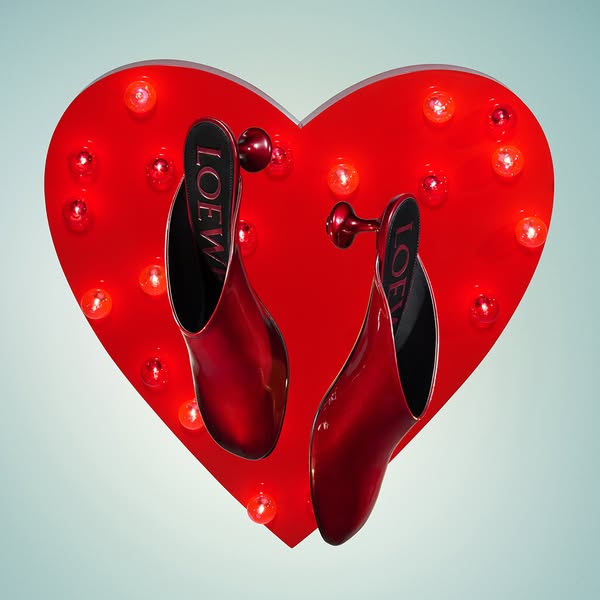 This ad showcases a pair of red Loewe heels against a red heart-shaped backdrop with lights, creating a visually strikin