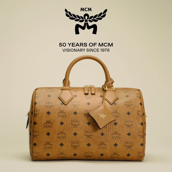 This image ad showcases an MCM satchel bag in their signature cognac-colored monogrammed leather, and celebrates the bra