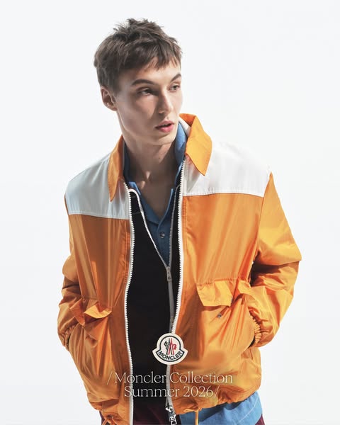 This ad for the Moncler Summer 2026 collection features a young man wearing an orange and white bomber jacket against a 