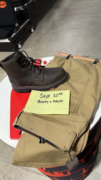 This ad showcases a pair of work boots and matching work pants with a handwritten note that promotes a 10% off deal when