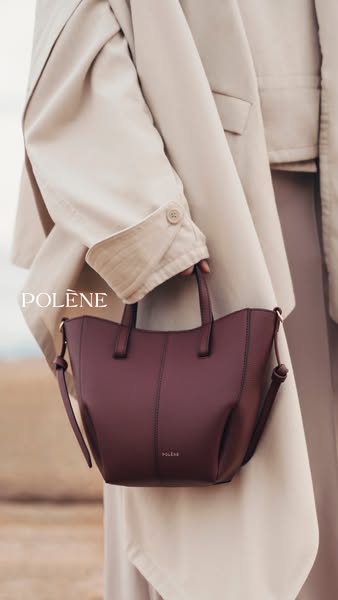 This image ad showcases a woman holding a dark red handbag from the brand Polène. The focus of the ad is on the product 