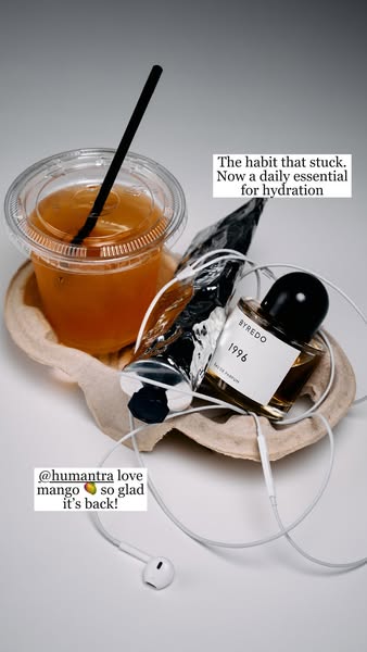 This ad features a flatlay of a Humanitra mango drink, perfume, lip balm, and headphones. The ad aims to communicate tha