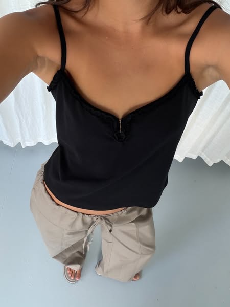 This image ad shows a person wearing a black top and beige pants. The photo is taken from an upward angle.