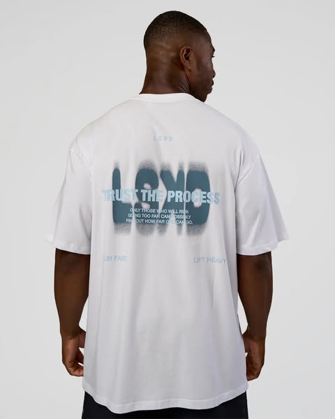 This image ad features a muscular man wearing a white t-shirt with a motivational message printed on the back. The ad pr