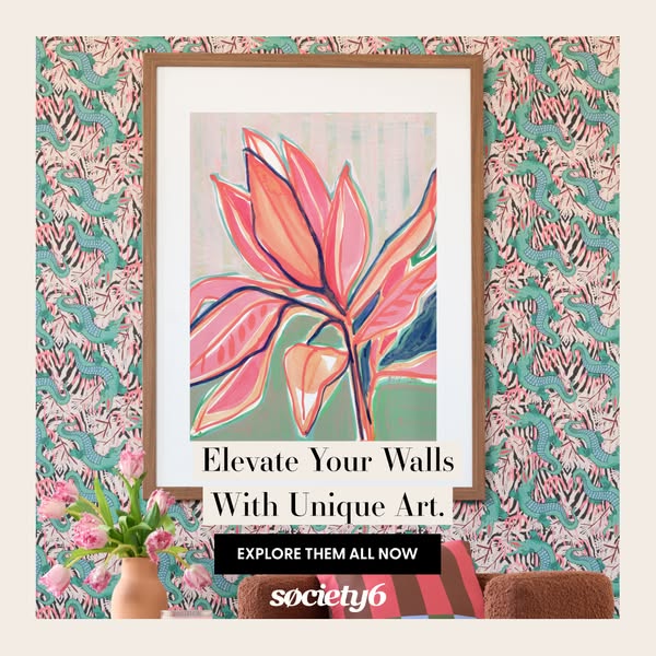 This ad for Society6 features a framed art print hanging on a patterned wall, styled to give off a trendy, homey feeling
