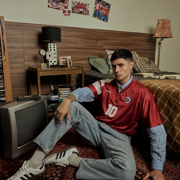 A brand advertisement showing a male model in a 1990s-themed bedroom.