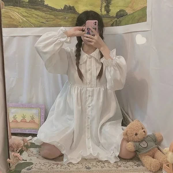 The image ad features a person wearing a white dress, taking a mirror selfie. The background includes a painting, a tedd