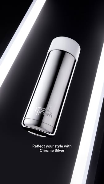 This ad showcases a chrome silver Frank Green reusable bottle against a black background with bright white lights. The a