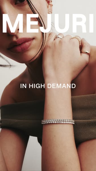 This ad by Mejuri features a close-up image of a woman wearing a Mejuri bracelet and various rings. The ad aims to promo