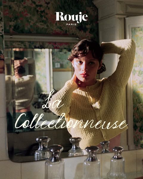 This image ad for Rouge Paris features a woman in a yellow sweater looking at herself in the mirror. The ad promotes the