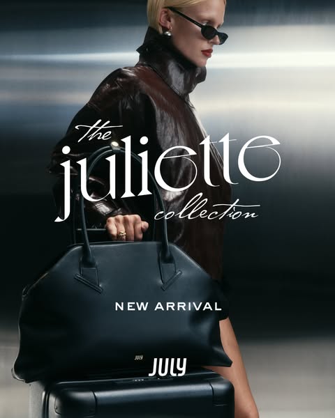 This image ad promotes the Juliette Collection from the brand July. It features a model with a black bag atop a black su