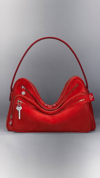 This ad showcases a red handbag with multiple zippers and compartments. The bag is presented against a neutral backgroun