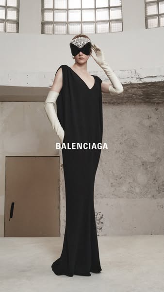 This ad features a high-fashion shot of a model in a Balenciaga dress. The stark background and limited color palette em