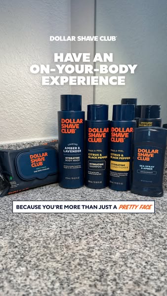 A static image ad for Dollar Shave Club body care products, featuring an array of products against a bathroom backdrop, 