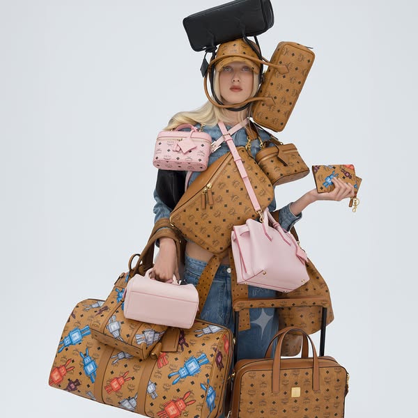 An image shows a person with a number of bags on their head, shoulder and in their arms to highlight the variety of bags
