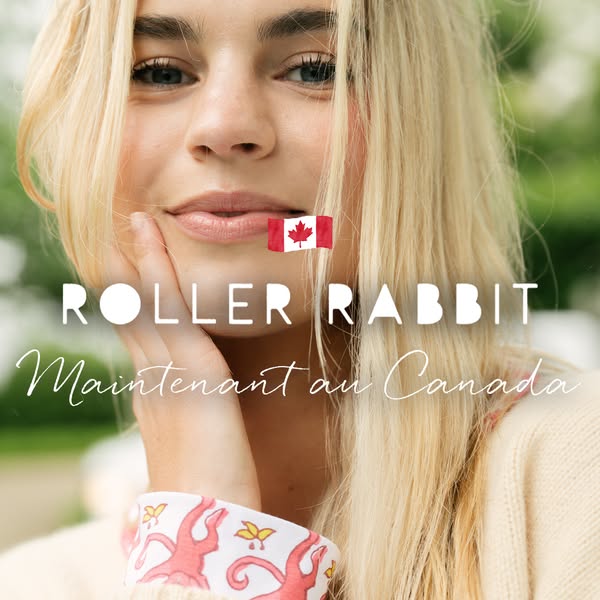 A young woman with long blond hair is smiling with her hand under her chin. The brand, Roller Rabbit, is announcing that