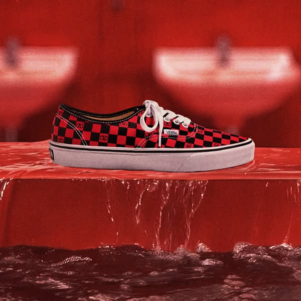 This ad showcases a Vans shoe with a red and black checkerboard pattern and the Valentino logo. The shoe is placed on a 