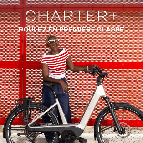 This ad is for Charter+ e-bikes and shows a woman smiling as she leans against her bike. The ad aims to convey that Char