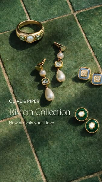 A flatlay image showcases the jewelry from the Olive & Piper Riviera Collection on a textured green tile background.