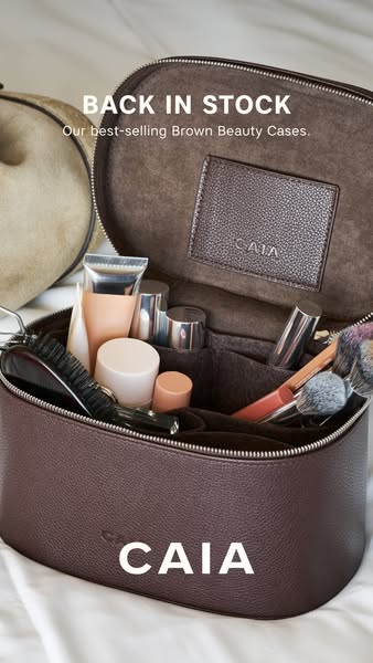 This image ad features a CAIA Cosmetics brown beauty case. The ad highlights that the beauty case is back in stock, sugg