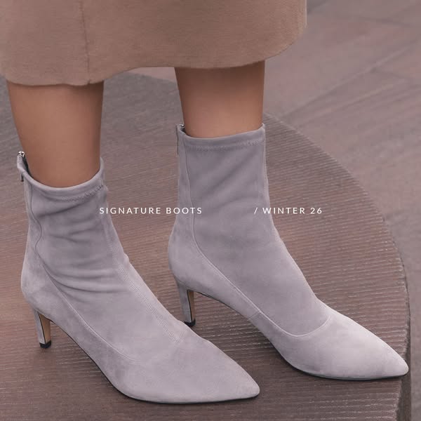 This ad showcases a pair of heeled suede ankle boots, presenting a sophisticated and fashionable product for the winter 