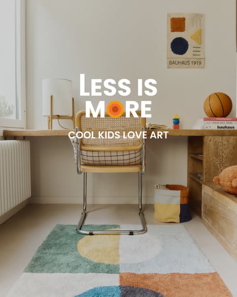 The ad is a full shot of a child's bedroom decor. A rug with shapes covers the floor. A rattan chair is in front of 
