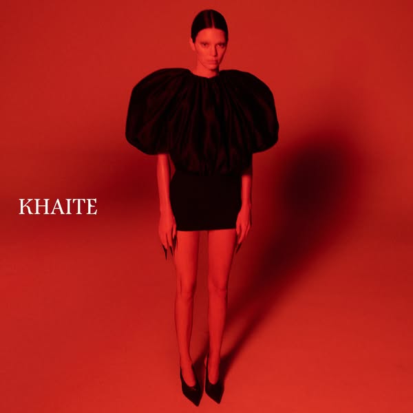 This image ad features a woman in a black dress and black heels on a red background. The brand, Khaite, is featured prom