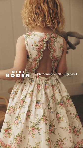 This ad for Mini Boden features a young child wearing a floral print dress with an open back design. The ad features the